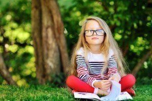 Blond girl with glasses reading