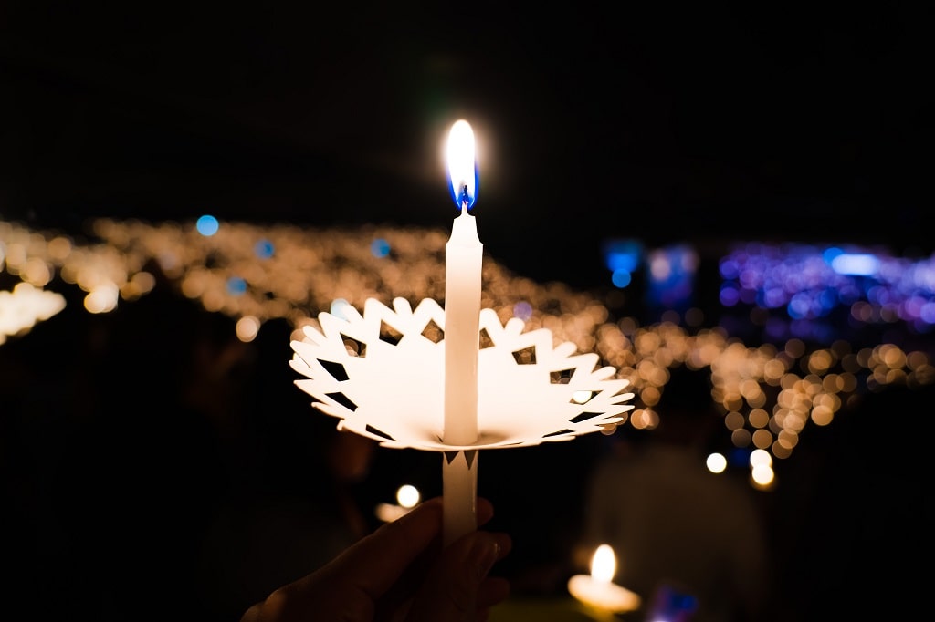 Christmas Eve candelight service, hand holding candle, Advent